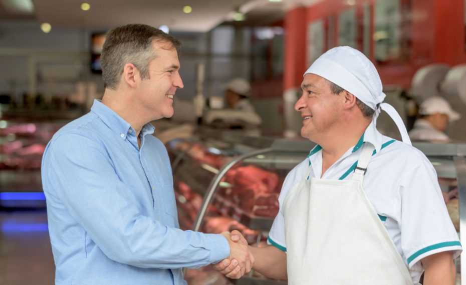 Business professionals shaking hands in supplier facility